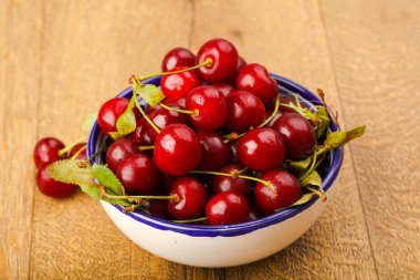 Ahşap arka plan üzerinde kase kiraz çilek 