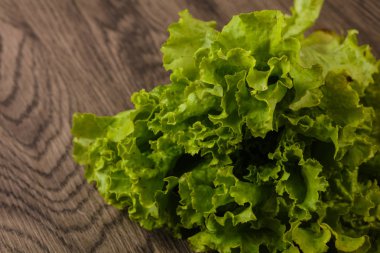 Ahşap arka plan üzerinde taze yeşil salata yaprakları 