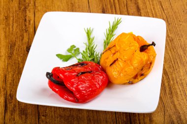 Izgara biber biberiye ve ahşap arka plan üzerine maydanoz ile