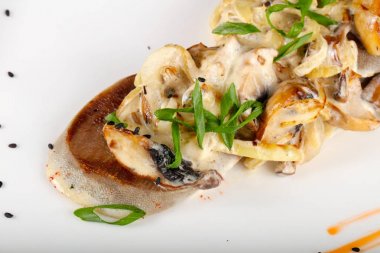 Kavrulmuş mantar beyaz tabakta diliyle