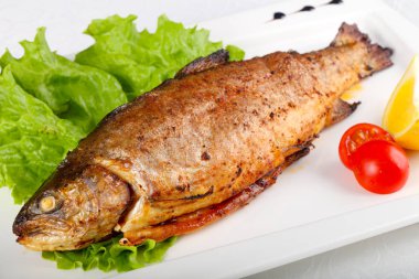 Plaka üzerinde limonlu ızgara alabalık 