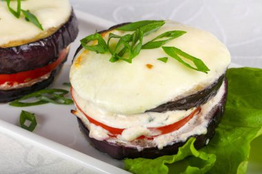 Mutfak masasında beyaz tabakta fırında patlıcan