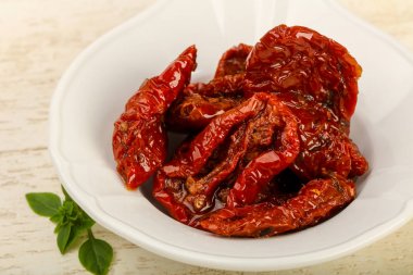 Kase zeytinyağı fesleğen ile kurutulmuş domates yaprakları, ahşap masa arka plan