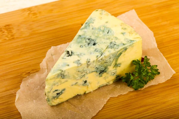 蓝色乳酪与香菜在烹调纸在木背景 — 图库照片