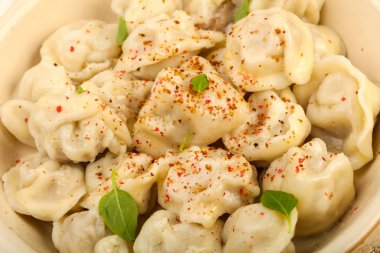 Otlar, yağlar ve baharatlar ile haşlanmış mantı 