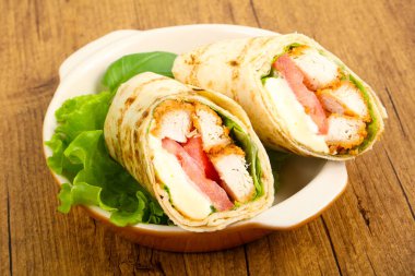 Ahşap arka plan üzerinde tavuk ekmek rulo ile salata yaprakları