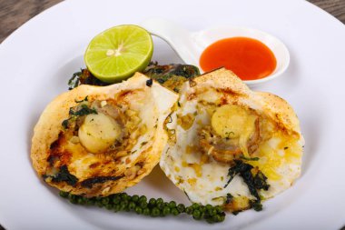 Ispanak, limon ve beyaz plaka üzerinde peynir ile pişmiş tarak