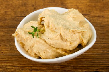 Susam ve kekik ile vejetaryen Humus ahşap arka plan üzerinde bırakır