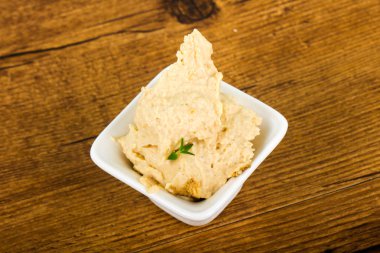 Susam ve kekik ile vejetaryen Humus ahşap arka plan üzerinde bırakır