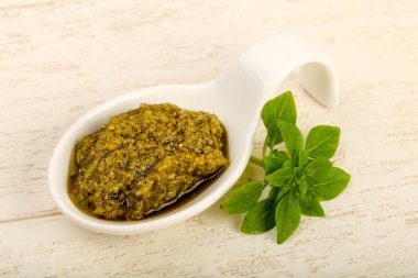 Fesleğenli pesto sos kase bırakır, ahşap masa arka plan