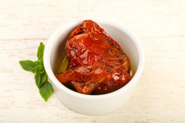 Kase zeytinyağı fesleğen ile kurutulmuş domates yaprakları, ahşap masa arka plan