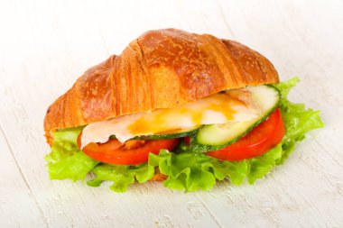 Kruvasan tavuk ve ahşap arka plan üzerinde domates ile