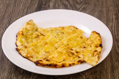 Naan peynir ve sarımsak ile. Hint ekmek plaka üzerinde ahşap arka plan