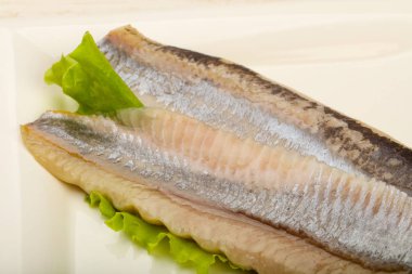 Ringa balığı filetosu salata yaprakları üzerinde 