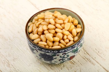 Sedir fındık yığın kase ahşap arka plan üzerinde