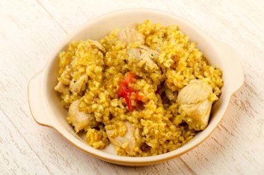 Bulgur tavuk, baharat ve ahşap arka plan üzerinde domates ile