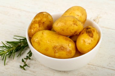 Ahşap masa arka plan üzerinde otlar ile ham genç patates