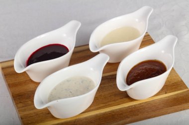 Soslar ürün yelpazesine ahşap arka plan üzerinde beyaz kase içinde karıştırın