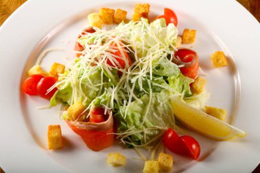 Sezar salata karides ve ahşap arka plan üzerine parmesan peyniri ile