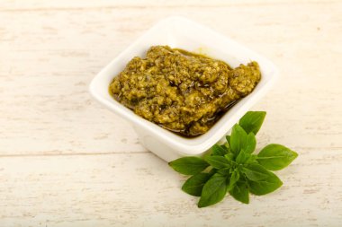 Fesleğenli pesto sos kase bırakır, ahşap masa arka plan