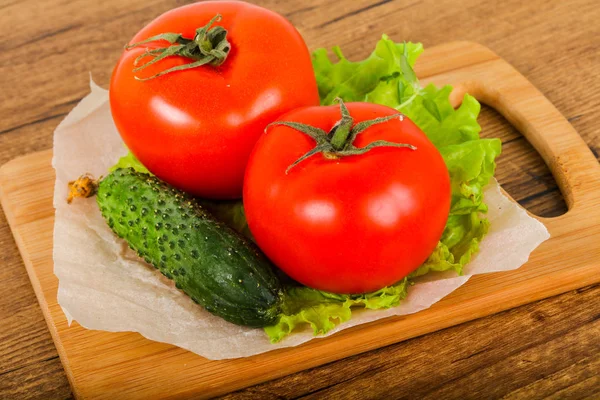 Salatalık ve domates salatası ile ahşap arka plan üzerinde bırakır 