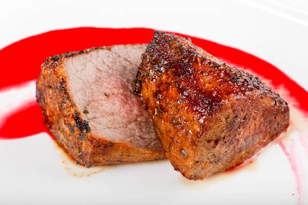 Rib-eye steak with sauce in white plate