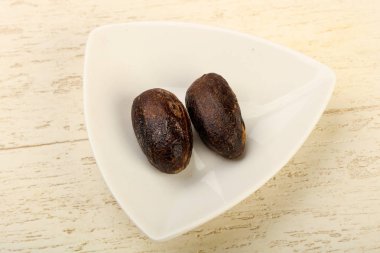 Culinare için iki Nutmegs ahşap arka plan üzerinde kullanın