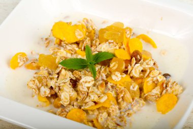 Muz, fındık ve ahşap masa arka plan üzerine nane ile müsli