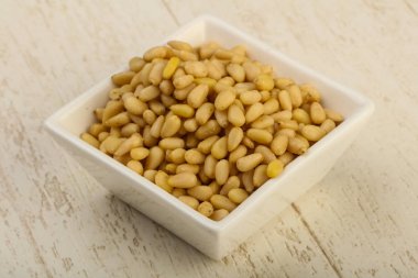 Sedir fındık yığın kase ahşap arka plan üzerinde