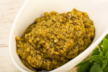 Fesleğenli pesto sos kase bırakır, ahşap masa arka plan