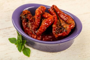 Kase zeytinyağı fesleğen ile kurutulmuş domates yaprakları, ahşap masa arka plan