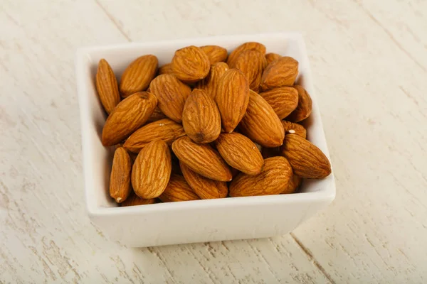 Badem ahşap arka plan üzerinde kase