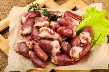 Çiğ tavuk kalpler yığın ahşap arka plan üzerine kekik Şubesi ile