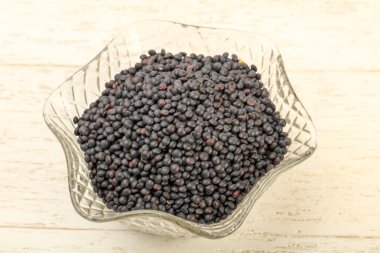 Kase üzerinde ahşap arka plan yemek pişirmek için hazır siyah mercimek