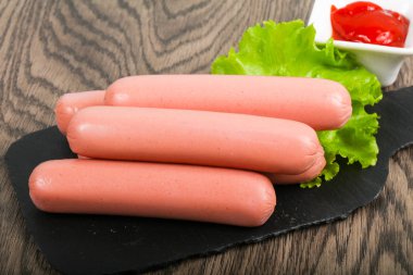 Salata ve ahşap arka plan üzerine ketçap ile sosis haşlama