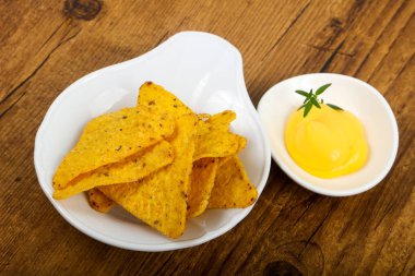 Ahşap arka plan üzerinde peynir soslu cips