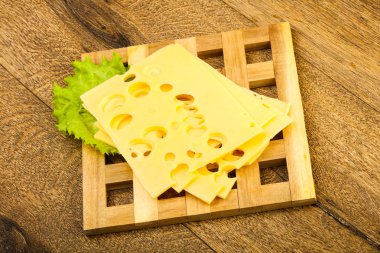 Ahşap arka plan üzerinde dilimlenmiş peynir salata yaprakları