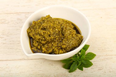 Fesleğenli pesto sos kase bırakır, ahşap masa arka plan