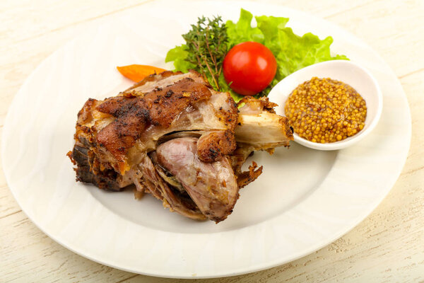 Roasted pork knee with Dijon mustard sauce, wooden table background