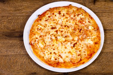 Karides ve beyaz tabak içinde yumuşak peynir pizza