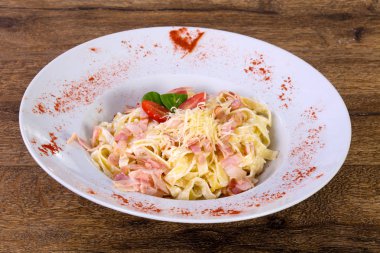 Carbonara makarna peynir ve domates ahşap arka plan üzerinde