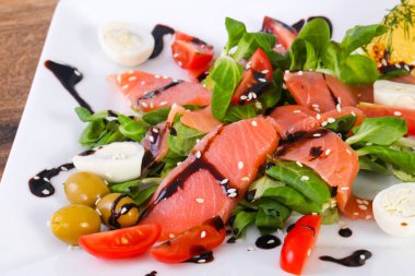 Yumurta ve Balzamico beyaz tabak içinde somon salatası