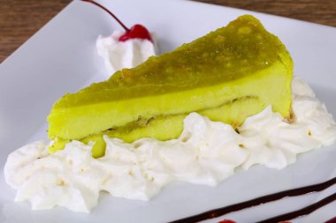 Cheesecake tatlı kivi ve krem beyaz plaka ile