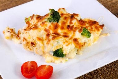 Beyaz tabak içinde peynirli fırında lahana