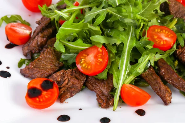 Ruccola ve beyaz tabakta domates ile sığır eti