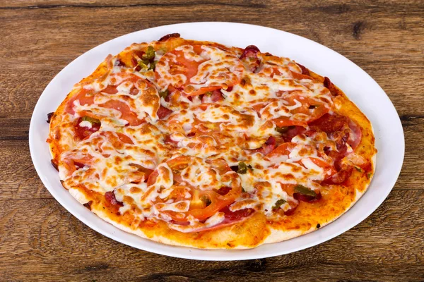 Sosis, biber ve domates ahşap arka plan üzerinde pizza