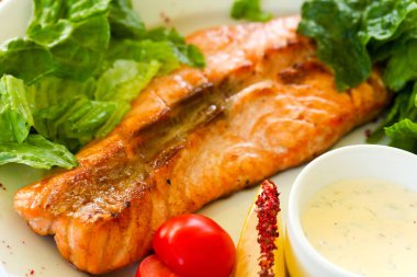 Izgara somon steak sos ve salata yaprakları ile