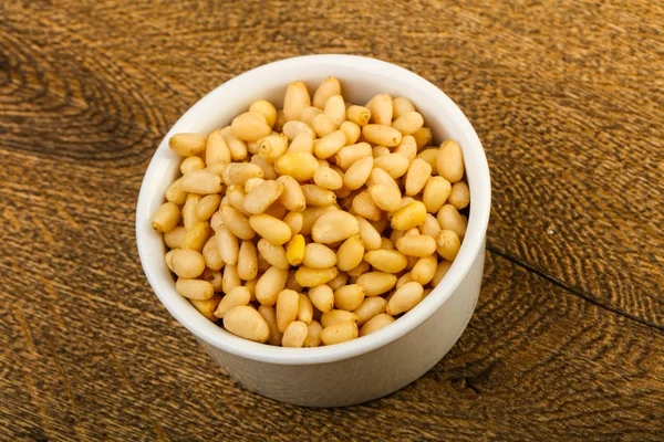 Sedir fındık yığın kase ahşap arka plan üzerinde