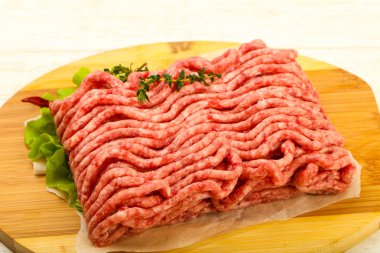 Kekik ve acı biber, ahşap masa arka plan ile çiğ kıyma et