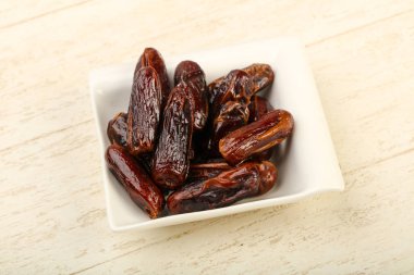 Tatlı tarihleri meyve yığın kase, ahşap masa arka plan